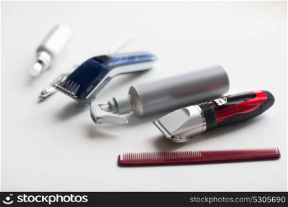 hair tools, hairstyle and hairdressing concept - styling sprays, trimmers or clippers with scissors and comb on white background. styling hair sprays, clippers, comb and scissors