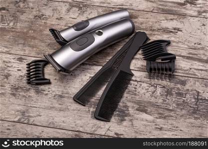 hair trimmer with comb on the wooden background
