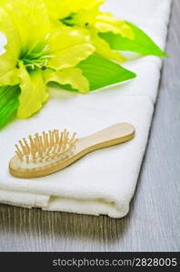 hairbrush and flower on towel