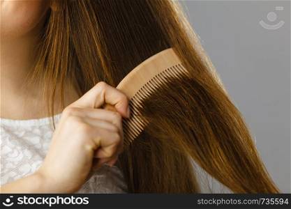 Haircare and morning hairstyling concept. Happy woman brushing her long dark brown hair. Happy woman brushing her hair