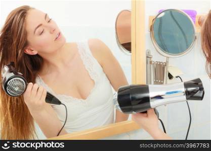 Haircare. Beautiful long haired woman drying hair in bathroom