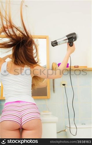 Haircare. Beautiful long haired woman drying hair in bathroom rear view