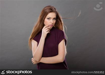 Haircare, beauty, hairstyling concept. Portrait of young attractive brunette woman wearing dark tshirt having windblown beautiful long brown hair.. Attractive brunette woman with windblown hair