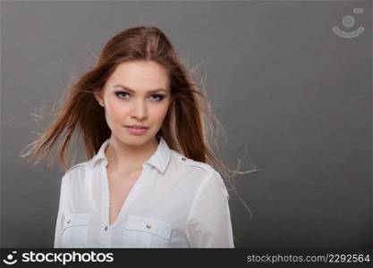Haircare, beauty, hairstyling concept. Portrait of young attractive brunette woman wearing white shirt having windblown beautiful long brown hair.. Attractive brunette woman with windblown hair