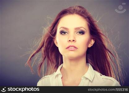 Haircare, beauty, hairstyling concept. Portrait of young attractive brunette woman wearing white shirt having windblown beautiful long brown hair.. Attractive brunette woman with windblown hair