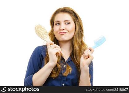 Haircut coiffure haircare concept. Woman with long brown wavy hair holding brush and comb.. Girl long hair with comb brush