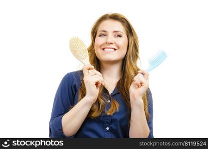 Haircut coiffure haircare concept. Woman with long brown wavy hair holding brush and comb.. Girl long hair with comb brush
