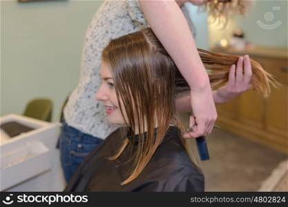 hairdresser cutting clients hair in a beauty salon