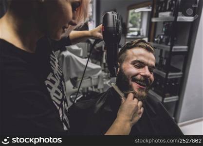hairdresser drying beard handsome man