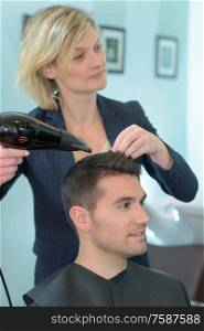 hairdresser drying hair of a man