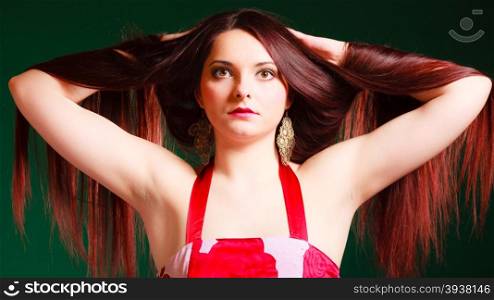 Hairdresser, hairstylist and haircare. Long haired beauty woman creating coiffure. Studio shot on green background.