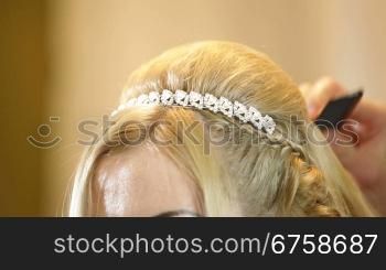 Hairdresser pinning up bride&acute;s hairstyle before the wedding