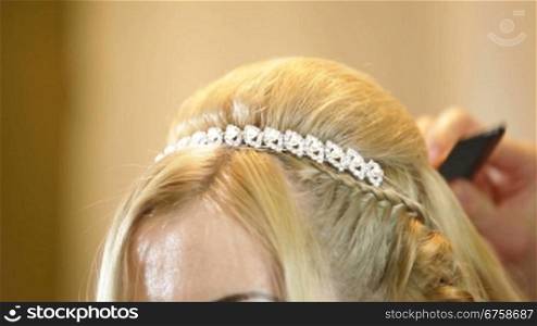 Hairdresser pinning up bride&acute;s hairstyle before the wedding