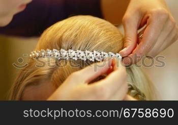 Hairdresser pinning up bride&acute;s tiara before the wedding