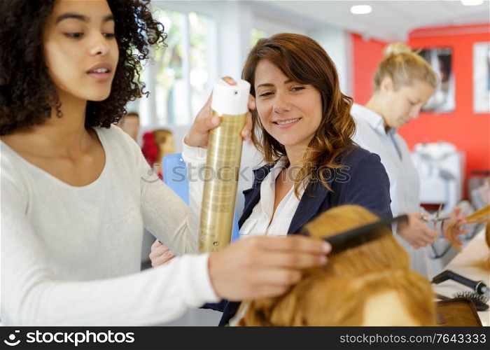 hairdresser spraying gel on hair for styling purposes