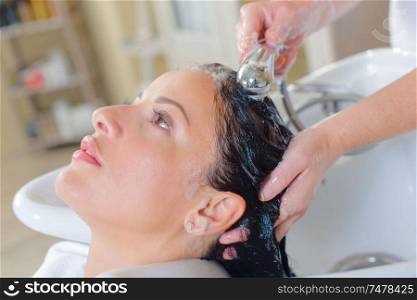 Hairdresser washing a customer's hair