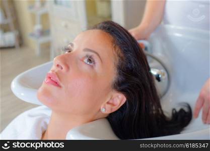 Hairdresser washing a woman&rsquo;s hair