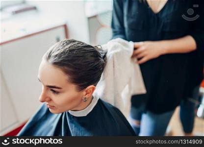 Hairdresser works with hair spray, female client in hairdressing salon. Hairstyle making in beauty studio. Hairdresser works with hair spray, hairdressing