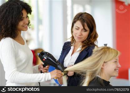 hairdressing apprentice ironing the clients hair