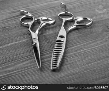 hairdressing equipment like different scissors on wooden table in professional hairdressing salon