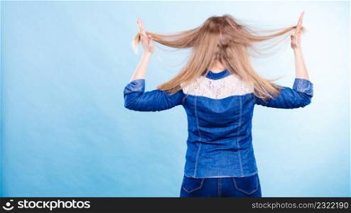 Hairstyle and hairdo. Haircare concept. Back view of blonde woman playing with straight long hair. Hairstylist barber making coiffure.. Blonde woman playing with hair.