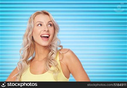hairstyle and people concept - happy smiling beautiful young woman with blonde hair over ribbed blue background. happy smiling young woman with blonde hair