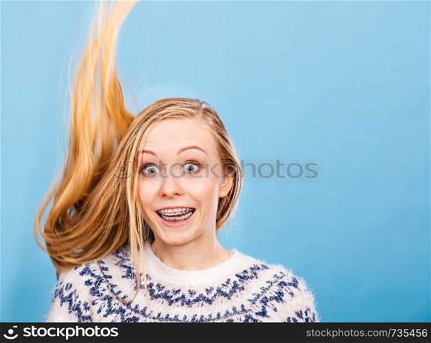 Hairstyles ideas, happiness concept. Crazy teenage woman wearing winter jumper with windblown blonde hair. Crazy blonde woman with windblown blonde hair