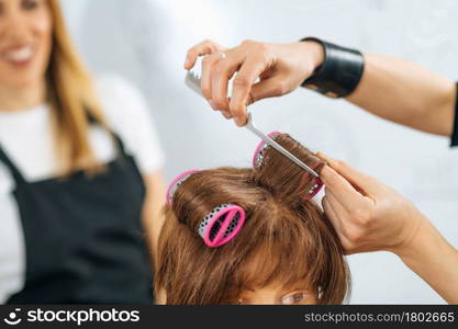 Hairstylist School - Female adult student practicing how to make hair styling with hair roller . Hairstylist School