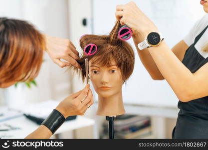 Hairstylist School - Female adult student practicing how to make hair styling with hair roller . Hairstylist School