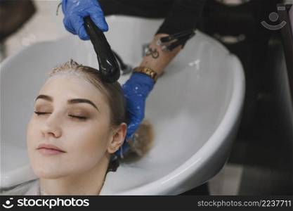 hairstylist washing client hair sink