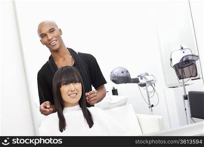 Hairstylist with female customer at beauty salon
