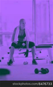 halethy young woman exercise with dumbells and relaxing on banch in fitness gym duo tone. young woman exercise with dumbells