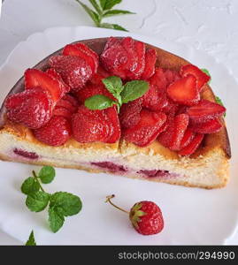 half a cake of cottage cheese and fresh strawberries on a ceramic plate, top view