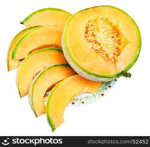 half and slices of ripe sicilian muskmelon (cantaloupe melon) on plate isolated on white background