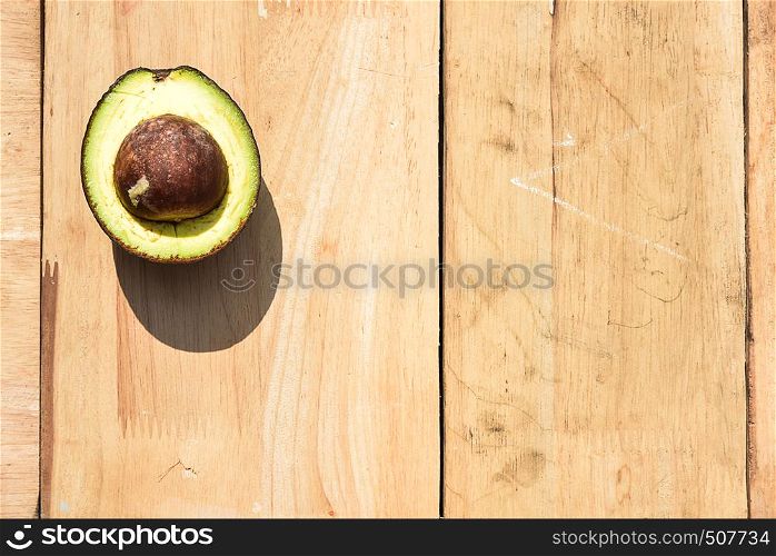 Half avocado on wooden board