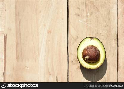 Half avocado on wooden board