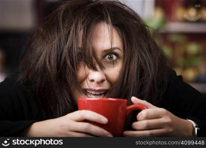 Half awake woman cradling a mug of coffee