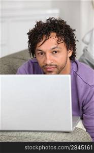 half-caste man with laptop in flat