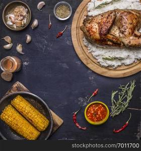 half chicken with rice on a cutting board with spices, corn and herbs, place for text,frame on wooden rustic background top view