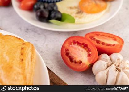 Half cut tomatoes, garlic and bread, put on a white background, Selective focus.