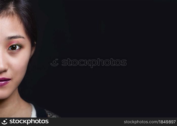 Half face beauty portrait of beautiful Asian American fashion model in makeup