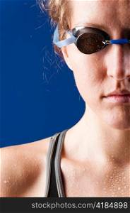half face of a looking at camera woman swimmer on blue background
