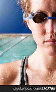 half face of a looking at camera woman swimmer on blue background