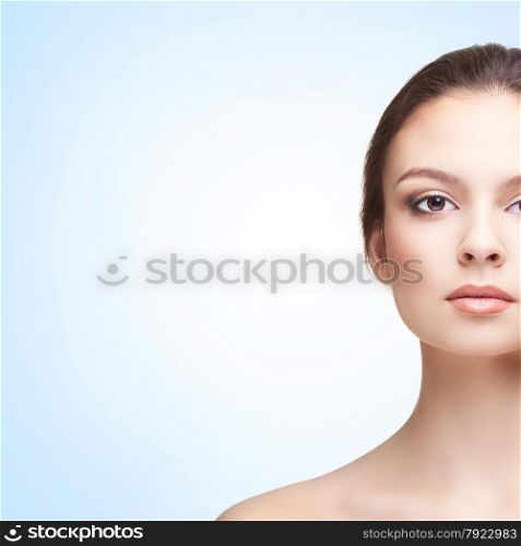 Half-face Portrait of Beautiful Young Woman on the Blue Background. Head and Shoulders