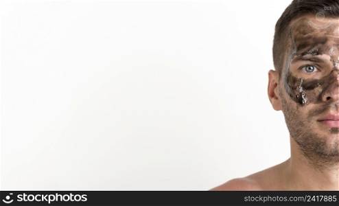 half face shirtless young man applied black mask his face against white background