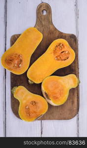 half fresh pumpkin on a brown cutting board, top view