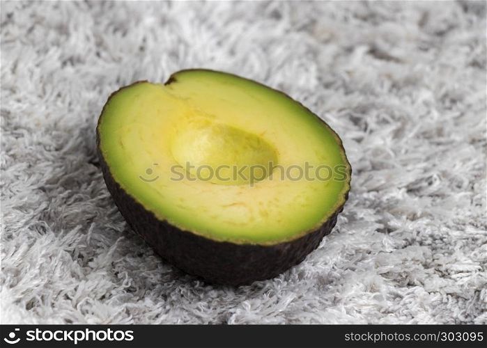 Half green sliced avocado on carpet