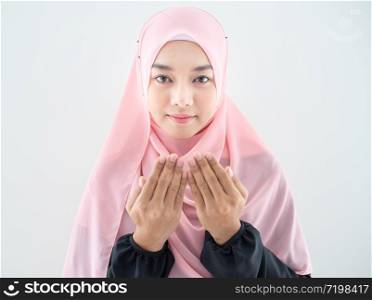 Half length front view of asian young beautiful muslim woman prayer dress hijab pray meditation in mosque for eid mubarak life and soul fasting of international islamic ramadan Namaz.