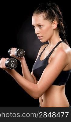 Half length of a young woman lifting dumbbells in sportswear