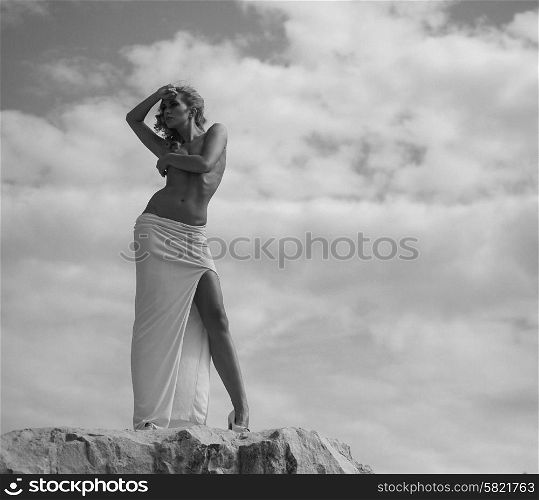 Half-naked lady looking at the rocks